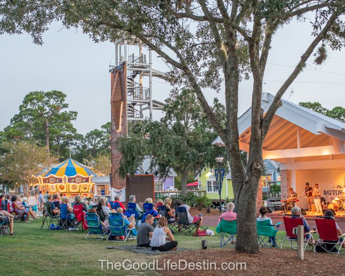 People on the events plaza lawn at Baytowne Wharf enjoying the concert
