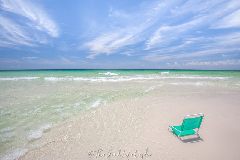 Beach chair in the clear water of Destin showing that July is the best time to visit if you want the most consistent water clarity