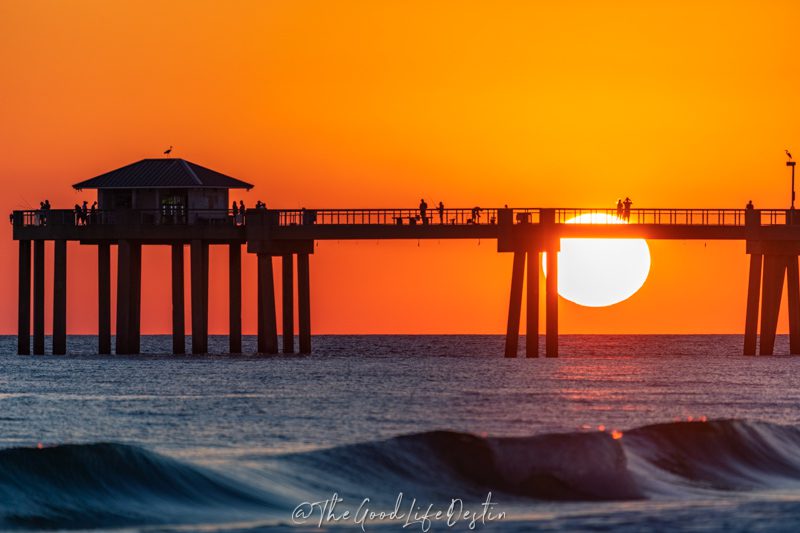 Sunset at the pier on Okaloosa Island with people walking on the pier