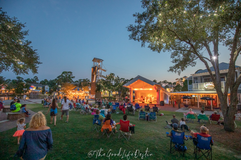 people enjoying a concert on the lawn at Baytowne Wharf. March is the best time to visit Destin if you enjoy outdoor concerts with spring weather