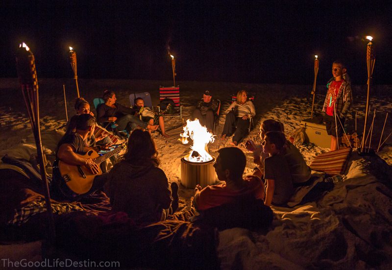 A family enjoying a beach bonfire in Miramar Beach