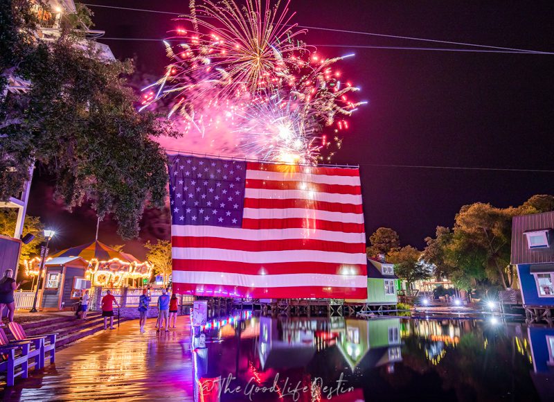 Fireworks over a flag in Baytowne Wharf. May is the best time to visit Destin for Memorial Day weekend festivities