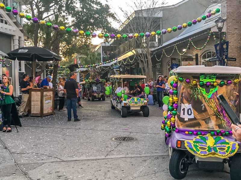 Golf carts parading down the streets of Baytowne Wharf for the Mardi Gras parade