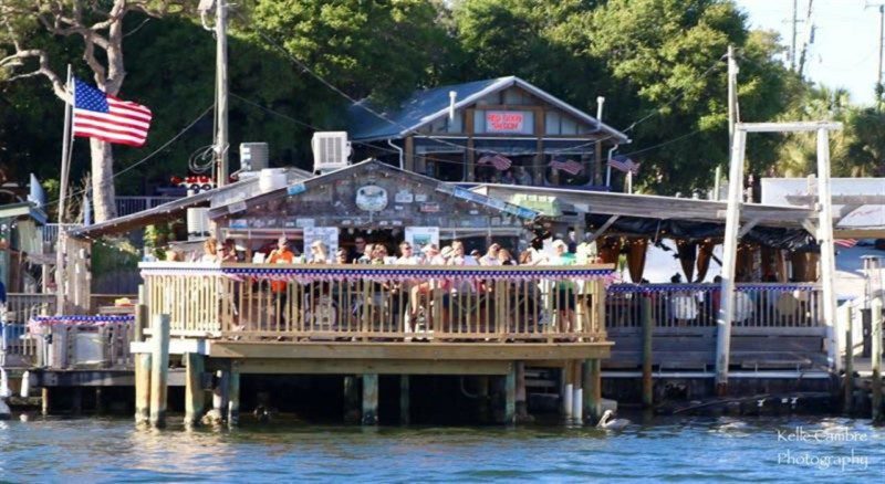 Outside deck of the Boathouse Oyster Bar and Red Door Saloon from the water on Destin Harbor