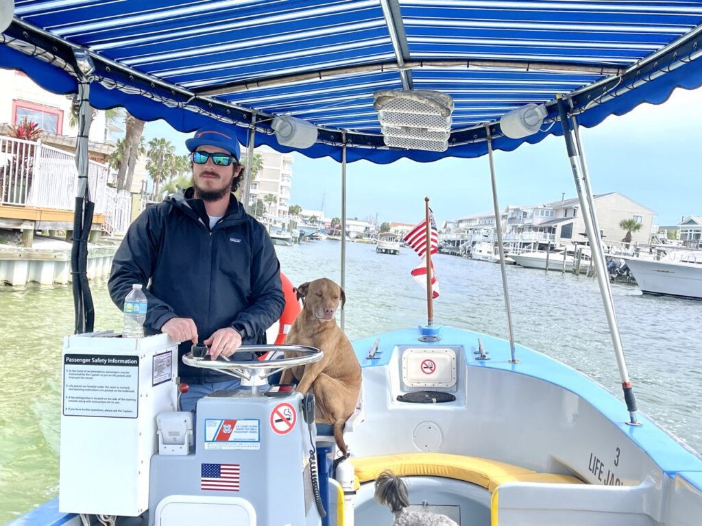 Captain with his dog driving the Destin Water Taxi