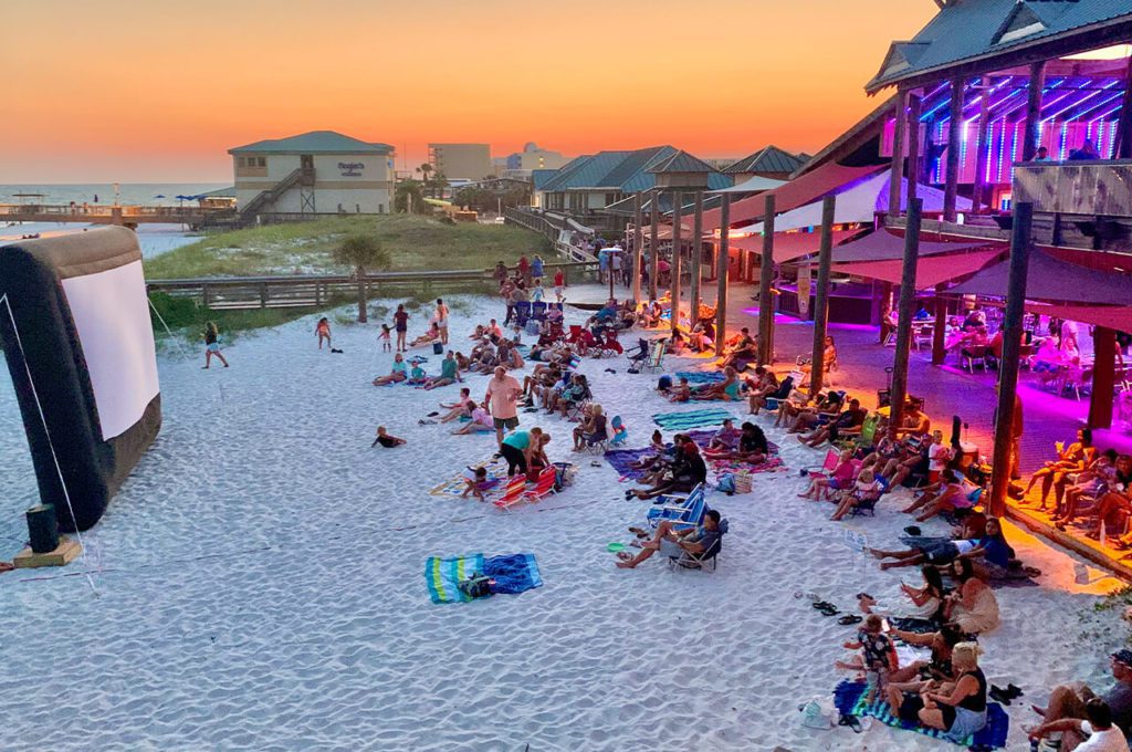 Destin visitors watching a movie on the beach at the Boardwalk on Okaloosa Island in June in Destin