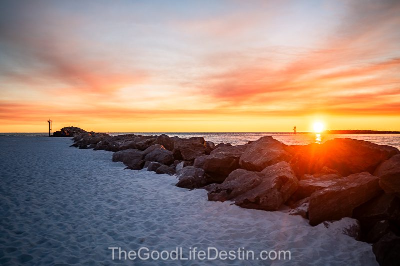 The sun setting over the beach at the jetties in Destin