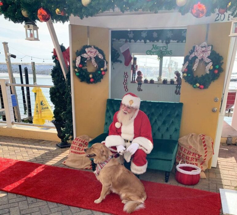 Santa posing with a dog at Harborwalk Village