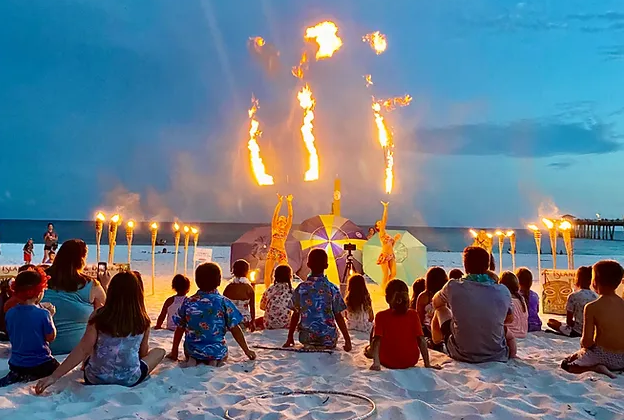 Kids watching a fire dancer on the beach at a luau on Okaloosa Island
