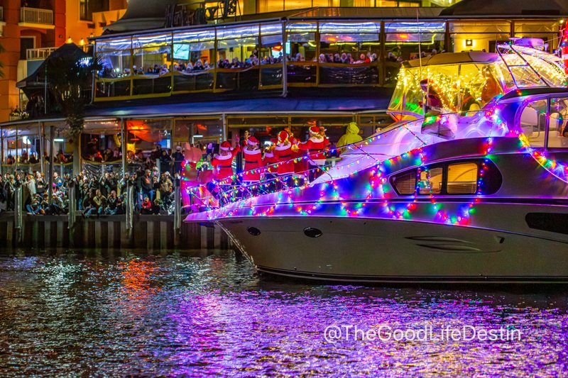 People waving at the Christmas parade boats from Harborwalk Village