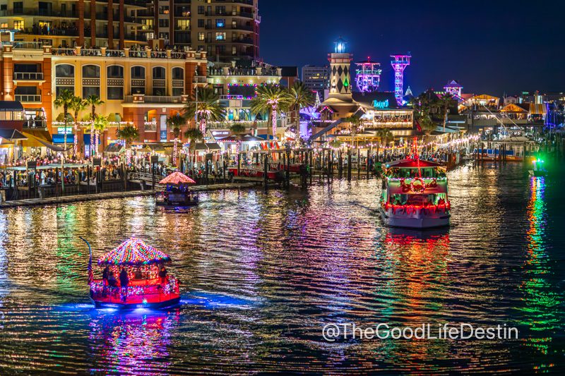 Boats in the Destin Harbor Christmas Parade in front of Harborwalk Village