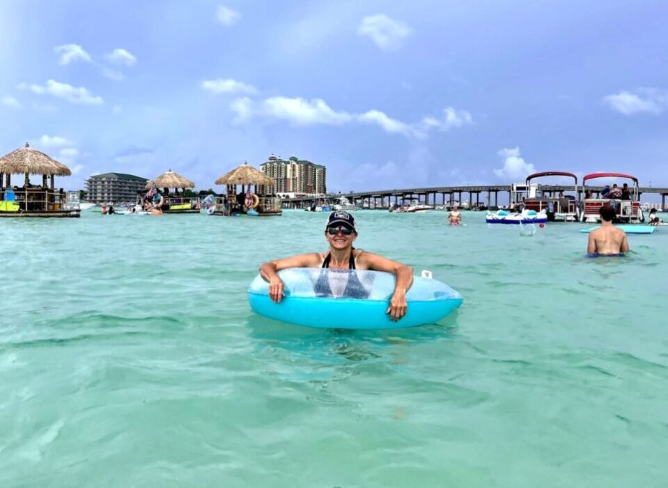 Sarah at Crab Island in a float chair with tikis and Emerald Grande in the background
