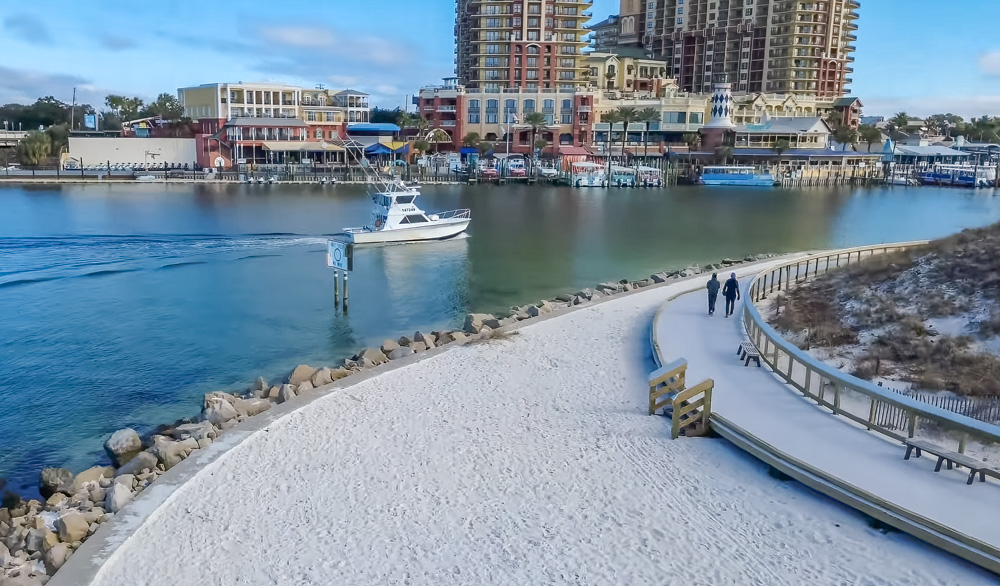 Fishing boat and walkers on the boardwalk path at Norriego Point Beach Park in Destin Florida 