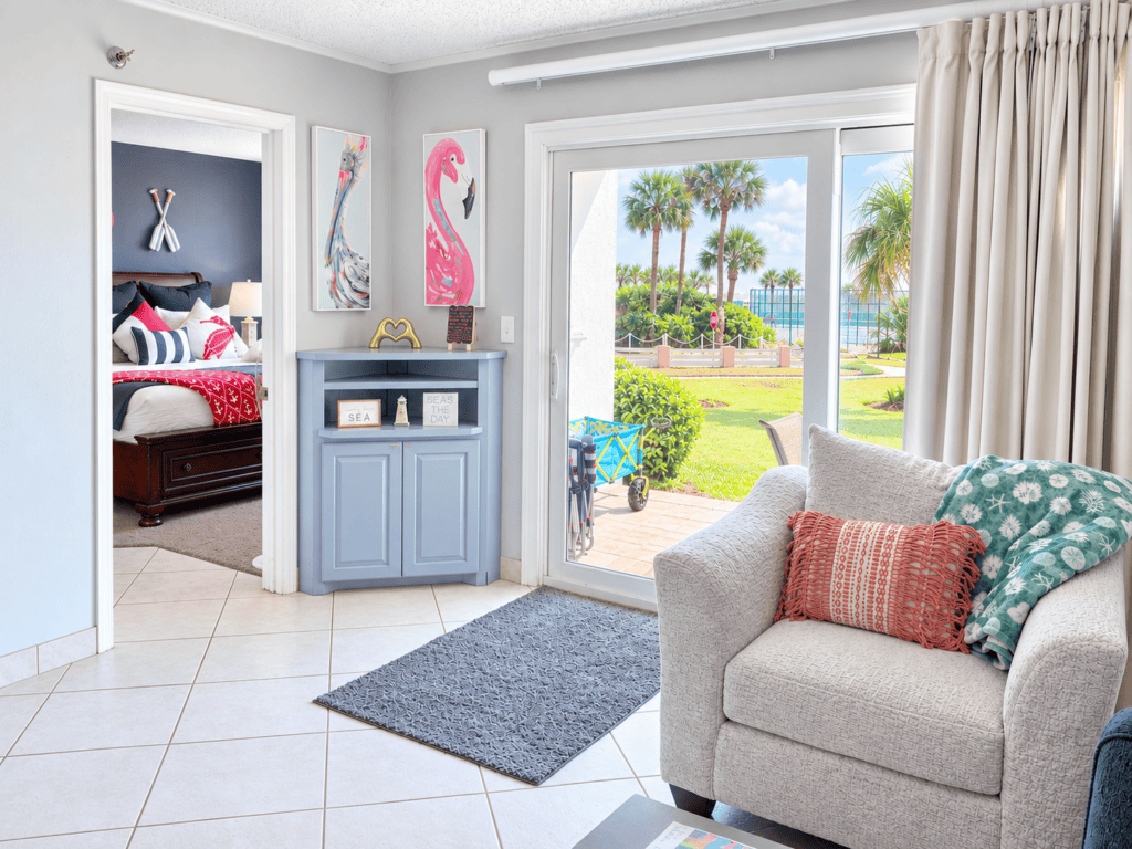 Bright coastal living room with sliding glass doors to palm trees, Destin FL
